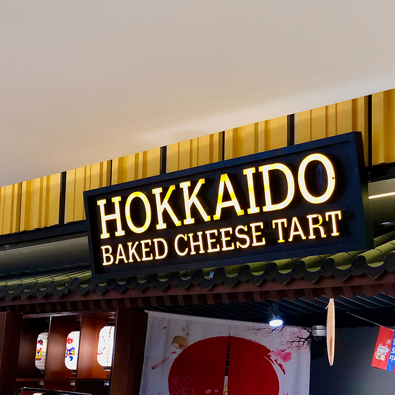 Bảng hiệu Hokkaido Baked Cheese Tart chất liệu gỗ kết hợp chữ nổi ánh vàng, thiết kế sang trọng hiện đại.