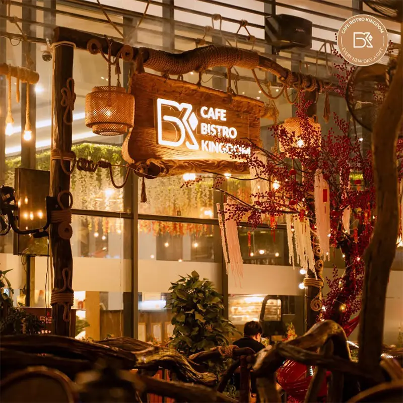 Bảng hiệu gỗ Bistro thiết kế sang trọng, kết hợp đèn chiếu sáng, tạo điểm nhấn thu hút ban đêm.