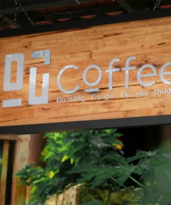 Bảng hiệu gỗ Gu Coffee phong cách tối giản, thiết kế chữ nổi trắng trên nền gỗ tự nhiên.