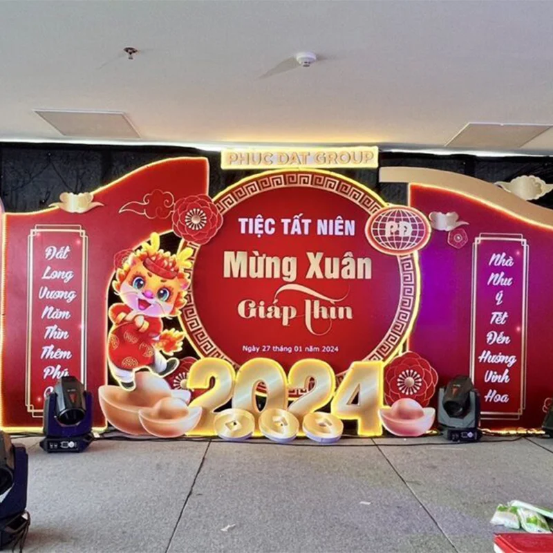 Thiết Kế Backdrop Chuyên Nghiệp - Bí Quyết Nâng Tầm Sự Kiện Của Bạn Backdrop tiệc tất niên thiết kế màu đỏ sang trọng, hình ảnh bánh chưng, pháo hoa, câu đối – thi công bởi Quảng Cáo Sắc Màu.