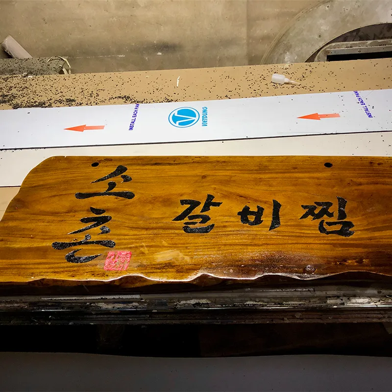 Bảng hiệu gỗ khắc laser chữ Trung Quốc với nét khắc chìm sắc sảo trên nền gỗ tự nhiên