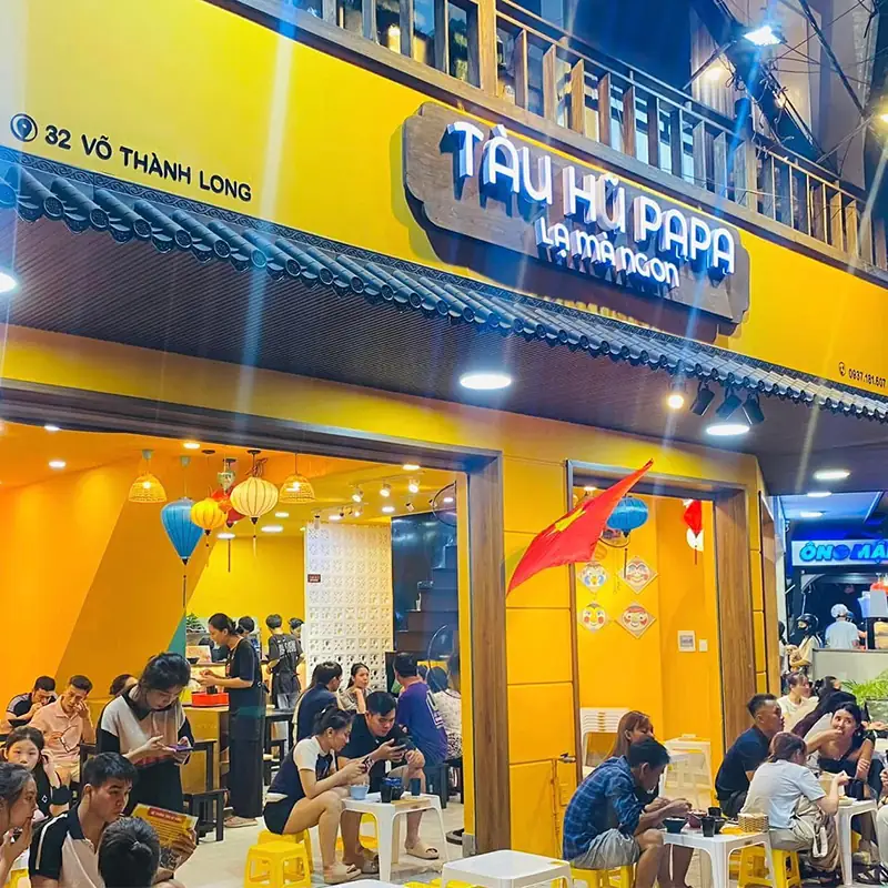 Bảng hiệu gỗ ngoài trời Tàu Hủ Papa với nền gỗ kết hợp đèn led nổi bật mặt tiền buổi tối