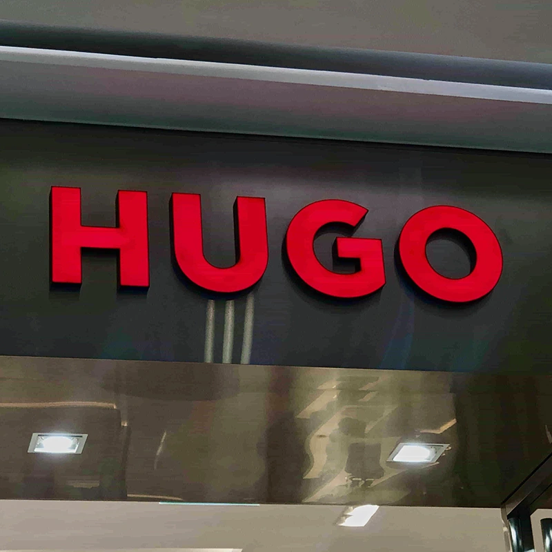 Bảng hiệu mica chữ nổi màu đỏ thương hiệu HUGO, thi công gắn trên nền mica đen tại TP.HCM