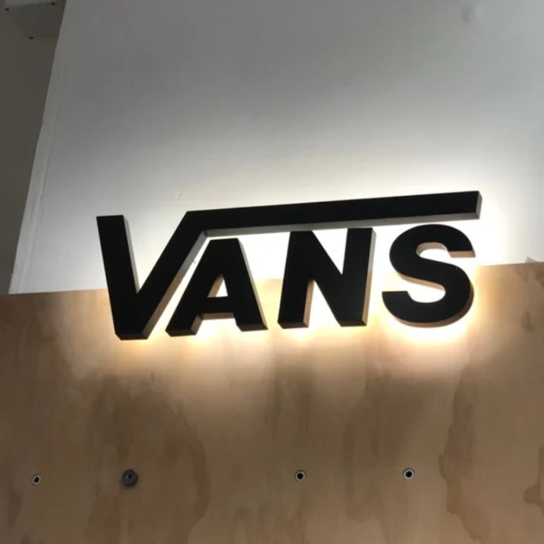 Chữ nổi mica đen thương hiệu Vans có đèn LED chiếu sáng nền trắng