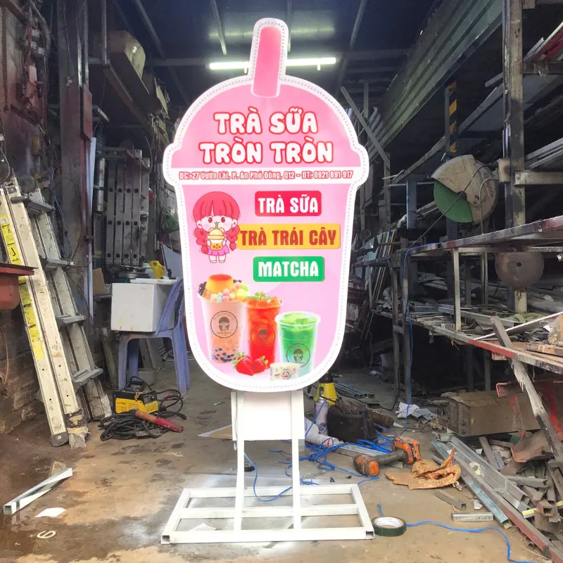 Hộp Đèn Mô Hình - Sự Kết Hợp Hoàn Hảo Giữa Ánh Sáng Và Nghệ Thuật Hộp đèn trà sữa hình tròn trụ màu hồng nổi bật trước cửa quán