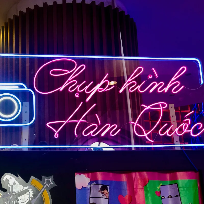 LED Neon uốn chữ Chụp hình Hàn Quốc màu hồng tím, nổi bật trong không gian studio.